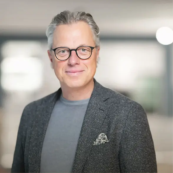 Hände zeigen auf Farb- und Materialmuster neben einem Küchenplan, Holzproben und Platten liegen auf einem Tisch